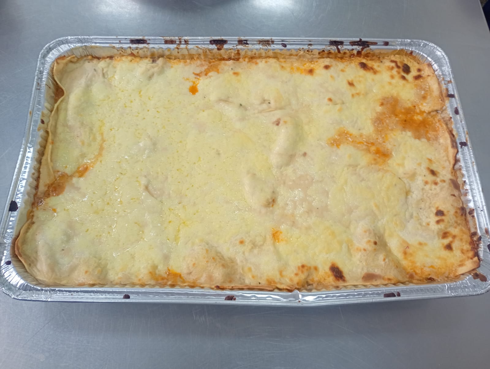 Lasaña gratinada lista para servir en evento